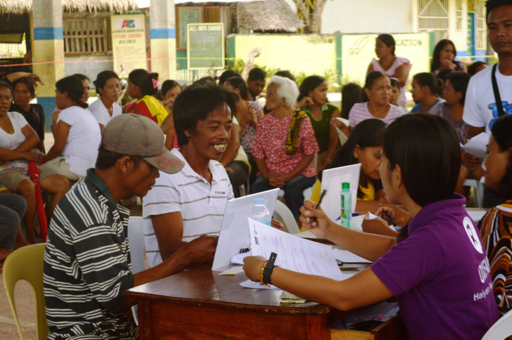 Two men being registered to receive their prepaid card in Tacloban