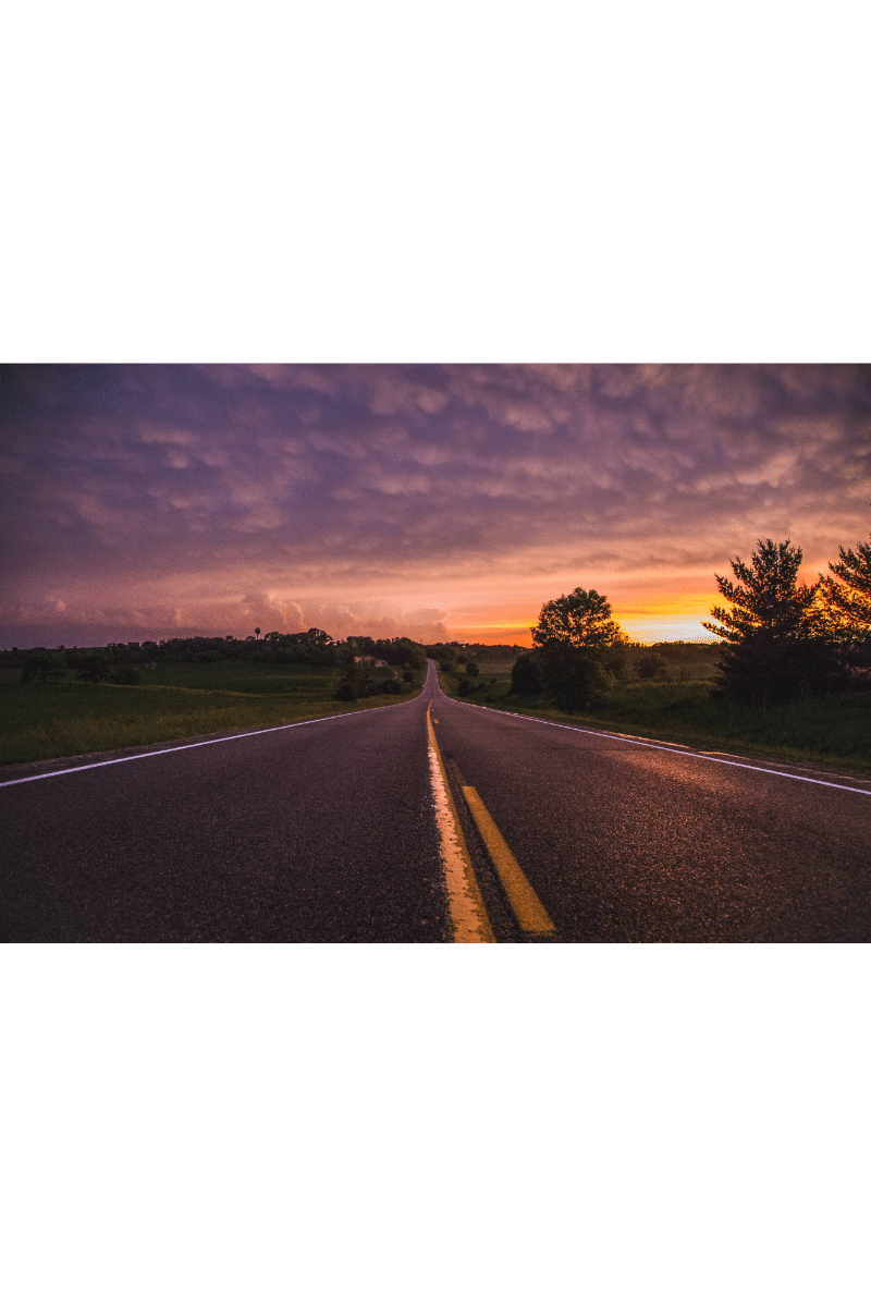 A long stretch of highway at sunset.
