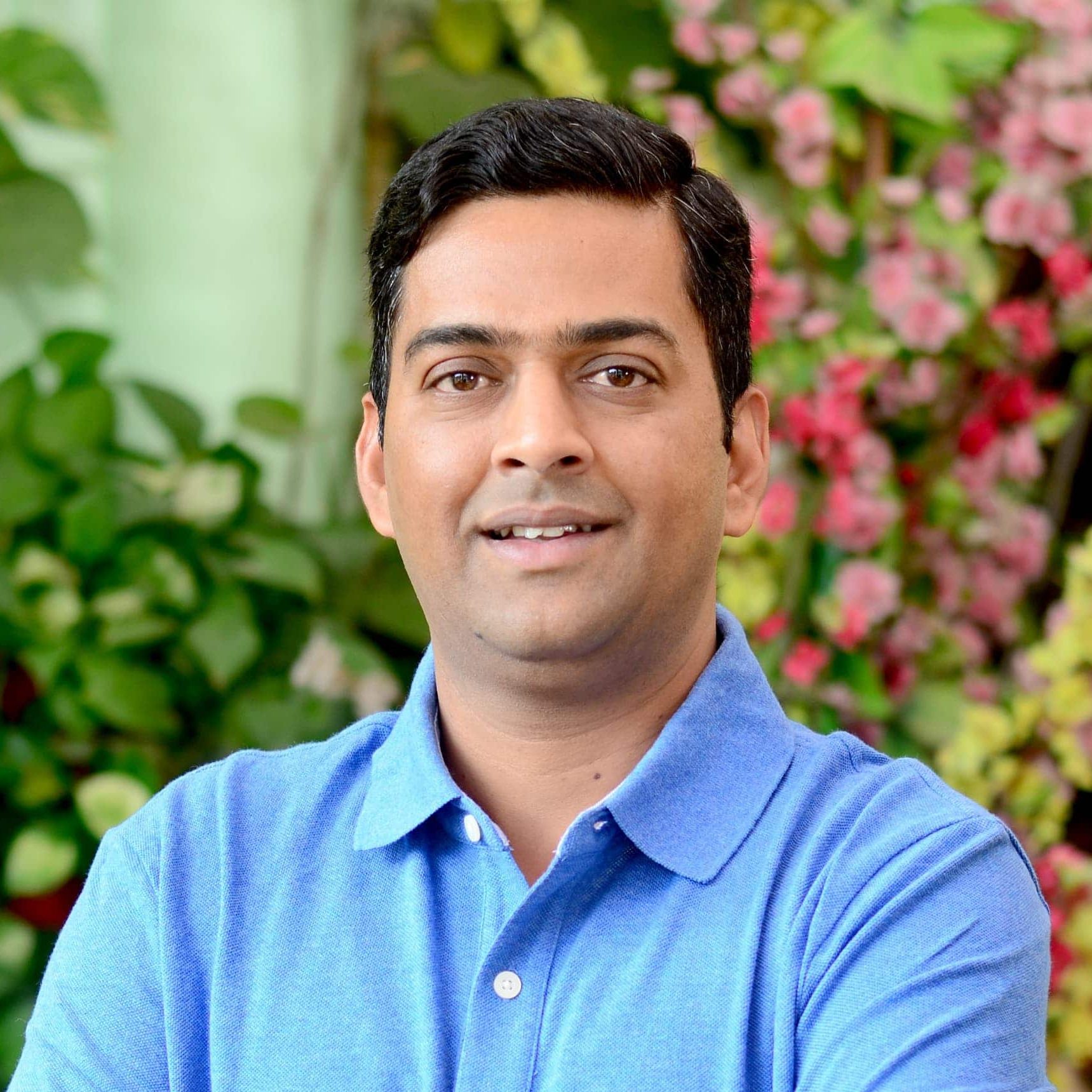 A headshot of Prateek, wearing a blue shirt.
